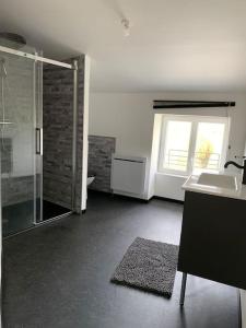 a large bathroom with a shower and a sink at P’tit Gîte du prieuré in Champdolent