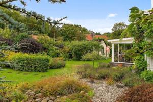 a garden with a house with a conservatory at Spacious House near Sea - Delightful shelted garden in Varberg