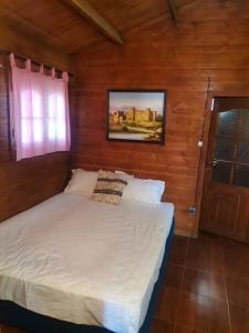 um quarto com uma cama num quarto de madeira em Auberge Ramz's em Beni Mellal