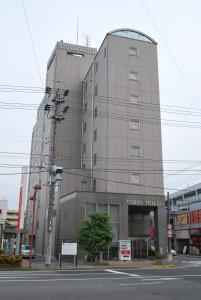 ein hohes Gebäude mit einem Schild an der Seite in der Unterkunft Suzuka Storia Hotel in Suzuka