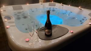 a bottle of wine in a hot tub with two wine glasses at Agat in Ustroń