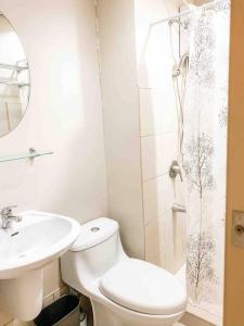 Un baño con inodoro, lavabo y ducha. en Studio in Avida towers Cebu IT park, en Cebú