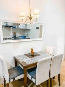 mesa de comedor con sillas blancas y lámpara de araña en Studio in Avida towers Cebu IT park, en Cebú