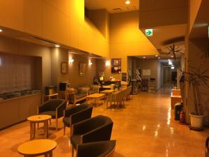فندق سوزوكا ستوريا في سوزوكا: غرفة انتظار مع طاولات وكراسي في غرفة