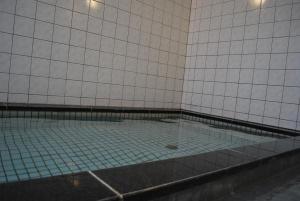 una piscina in una stanza con piastrelle bianche di Suzuka Storia Hotel a Suzuka