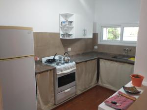 uma cozinha com um fogão e um frigorífico em Coneta, casa de Dios em San Fernando del Valle de Catamarca