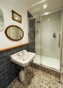 a bathroom with a sink and a shower at Millpool House in Dartmouth