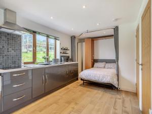 a kitchen with a bed and a sink in a room at Honey Bee - Uk43395 in Chardstock