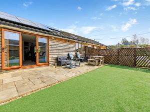 a backyard with a patio with a lawn at Honey Bee - Uk43395 in Chardstock
