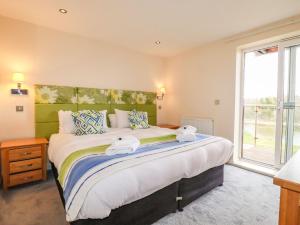 a bedroom with a large bed with towels on it at 207 The Glades - Retallack Resort and Spa in Saint Columb Major