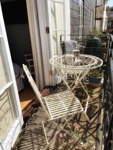 a white table and chairs sitting on a porch at Millpool House in Dartmouth