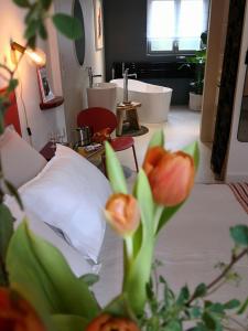 een slaapkamer met een bed en een badkamer met een bad bij Maison et Florescence in Nuits-Saint-Georges