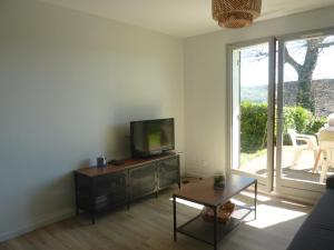 a living room with a television and a table at Houlgate in Houlgate