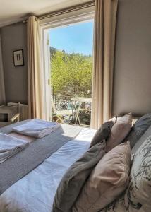 a bedroom with a bed and a large window at Millpool House in Dartmouth