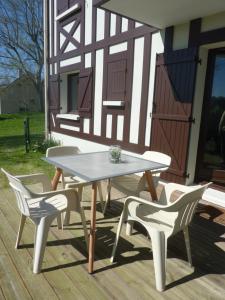a picnic table and two chairs on a deck at Houlgate in Houlgate
