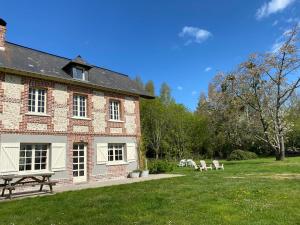 een bakstenen gebouw met een picknicktafel in een tuin bij Propriété à 5 km de Honfleur in Fourneville