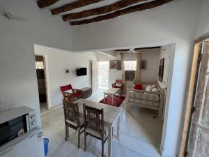 a kitchen and living room with a table and chairs at Beytsalaam Apartments in Lamu