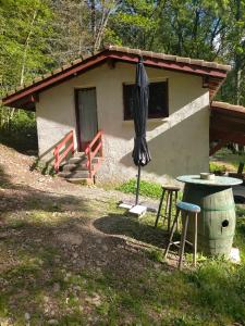 een klein huis met een paraplu en een tafel bij appartement meublé sur la route de Compostelle ! in Aire-sur-lʼAdour