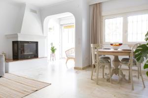 a living room with a table and a fireplace at Casa Jardín - residential area -free parking outdoor- Málaga Este in Málaga