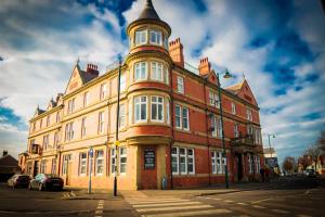 a large brick building with a tower on top of it at Stylish Apartment close to Beach & Town Centre in Prestatyn