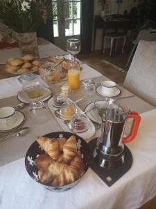 stół ze śniadaniem obejmującym rogaliki i sok pomarańczowy w obiekcie Maison et Florescence w mieście Nuits-Saint-Georges