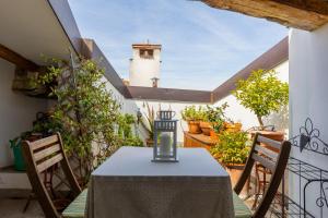 einen Tisch und Stühle auf einem Balkon mit einem Leuchtturm in der Unterkunft Italy prestigious historical attic in Bologna in Bologna