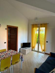salon ze stołem, krzesłami i telewizorem w obiekcie La casa di Mauro - Mare e ciclabile a pochi passi w mieście Riva Ligure