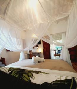 a bedroom with a white bed with a canopy at Recanto Villa São João in Palmeiras