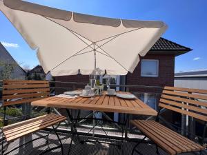 a wooden table with an umbrella on a balcony at Apartment in Uni- und Citynähe in Oldenburg