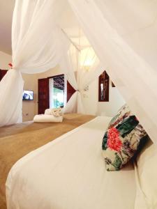 パウメイラスにあるRecanto Villa São Joãoのベッドルーム(白い大型ベッド、枕付)