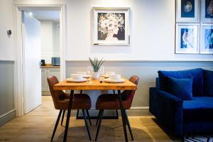 uma mesa de jantar com cadeiras e um sofá azul em Stylish Apartment close to Beach & Town Centre em Prestatyn