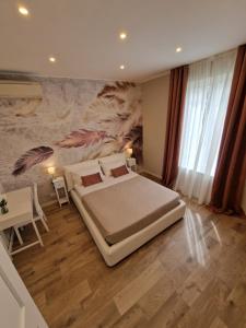 - une chambre avec un lit et une peinture murale dans l'établissement FLORA HOUSE, à La Spezia