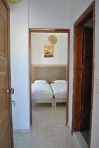 a hallway with two beds in a room with a mirror at Antigoni Apartments 'Olive Room' in Milatos