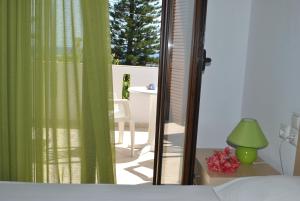 a bedroom with a bed and a sliding glass door at Antigoni Apartments 'Olive Room' in Milatos