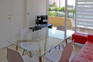 une salle à manger avec une table et des chaises en verre dans l'établissement Condominio Vista Azapa Piso 2 Dto 24, à Arica