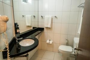 ein Bad mit einem Waschbecken und einem WC in der Unterkunft Firenze Business Hotel in Palhoça