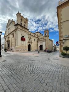 an old building with a clock tower on a street at El Callejón del Molino in Lucena