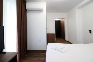 a bedroom with a white bed and a hallway at Бялата Къща 2 in Zlatograd
