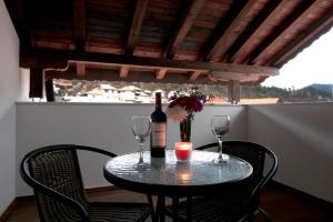 ein Tisch mit einer Flasche Wein und zwei Gläsern in der Unterkunft Бялата Къща 2 in Slatograd