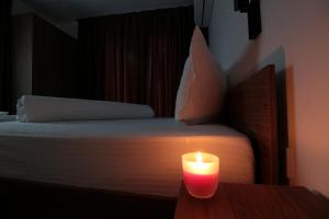 a candle sitting on a table next to a bed at Бялата Къща 2 in Zlatograd