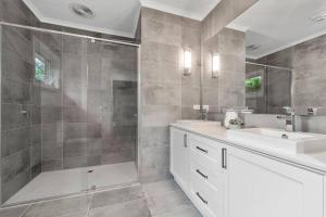 a bathroom with a shower and a sink and a mirror at Rosebud Lovely House 2 - Mornington Peninsula 4 BR 3 Bath 2 story holiday house - BBQ - Beach - Hot spring in Rosebud +37 photos