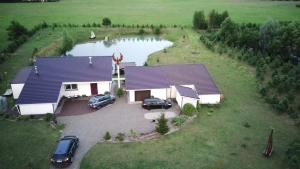 an aerial view of a house with cars parked in front at Villa Feniksas in Poškai