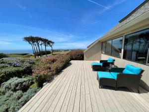 een houten terras met stoelen op een gebouw bij Panorama Ocean & Golf Fairway view in Bodega Bay