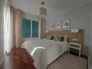 1 dormitorio con cama blanca y ventana en Horizon Dream, en Funchal