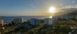 una città con il sole che tramonta sull'oceano di Horizon Dream a Funchal