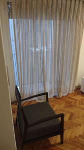a room with a chair and a window with curtains at Departamento de 2 ambientes en Recoleta 4 piso in Buenos Aires