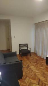 uma sala de estar com um sofá e uma cadeira em Departamento de 2 ambientes en Recoleta 4 piso em Buenos Aires