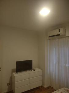 1 dormitorio con TV en un tocador con cama en Departamento de 2 ambientes en Recoleta 4 piso en Buenos Aires