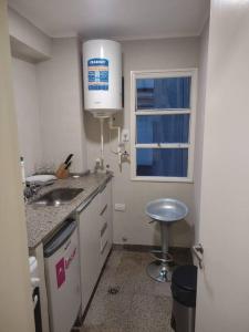una pequeña cocina con fregadero y ventana en Departamento de 2 ambientes en Recoleta 4 piso en Buenos Aires
