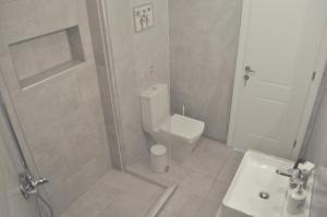 uma casa de banho com um WC, um chuveiro e um lavatório. em Zennova #9 City Center Pearl em Tessalônica